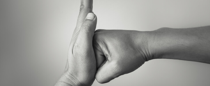 Two hands clasped together in a black and white photograph, symbolizing connection and unity