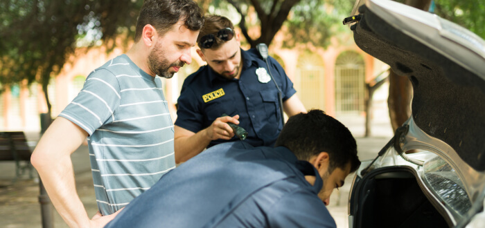 Two police officers inspecting the trunk of a car during a routine check for safety and compliance