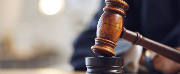 A judge's gavel rests on a polished wooden table, symbolizing authority and the judicial process