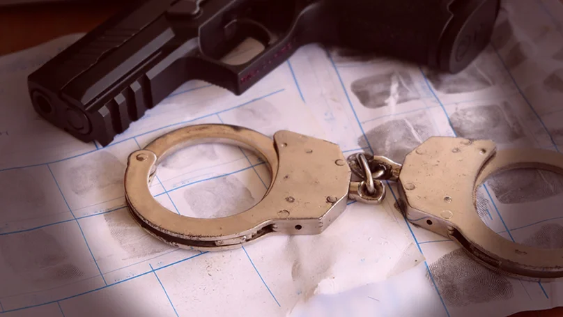 handgun, handcuffs, and a fingerprint sheet