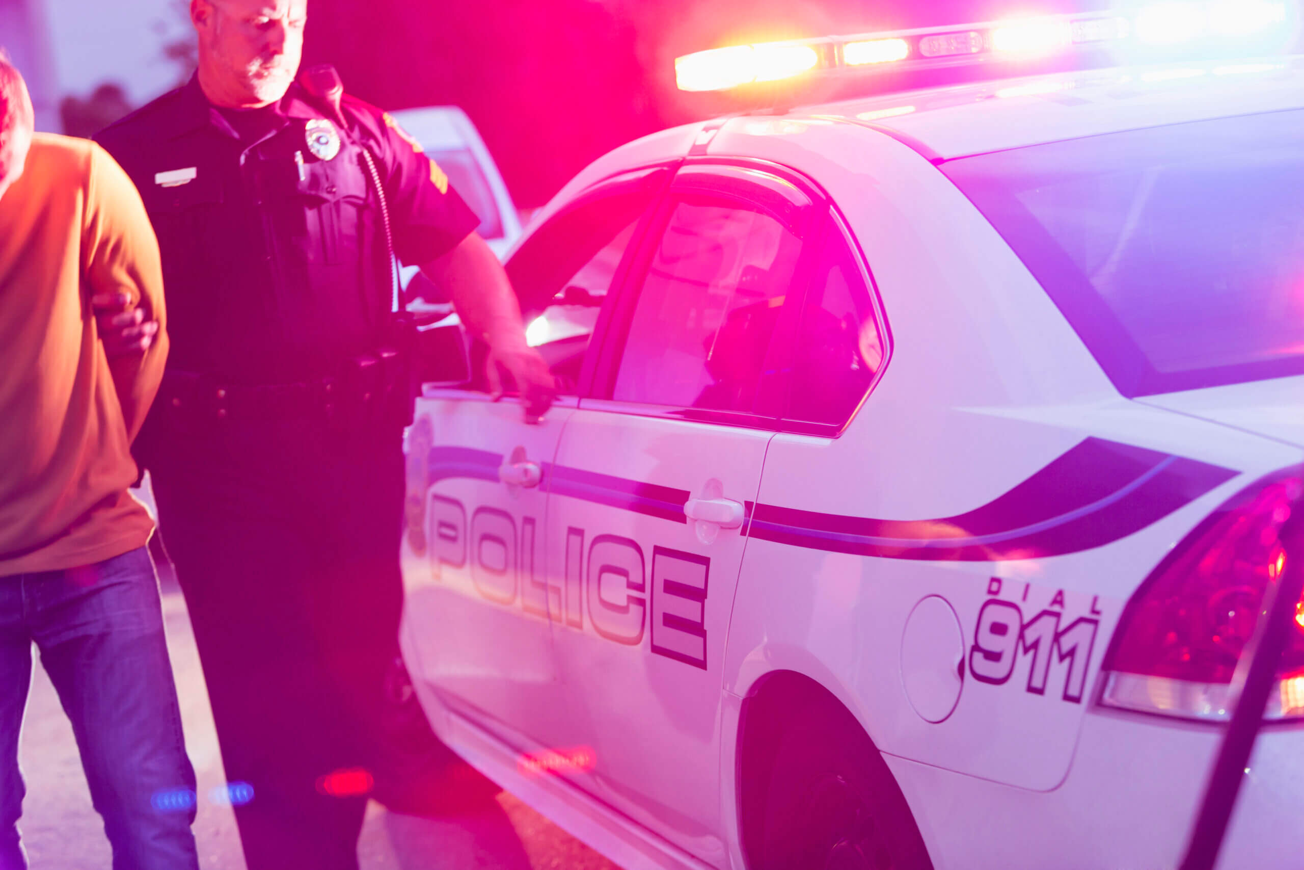 A man is being escorted by police officers, indicating a situation involving law enforcement intervention