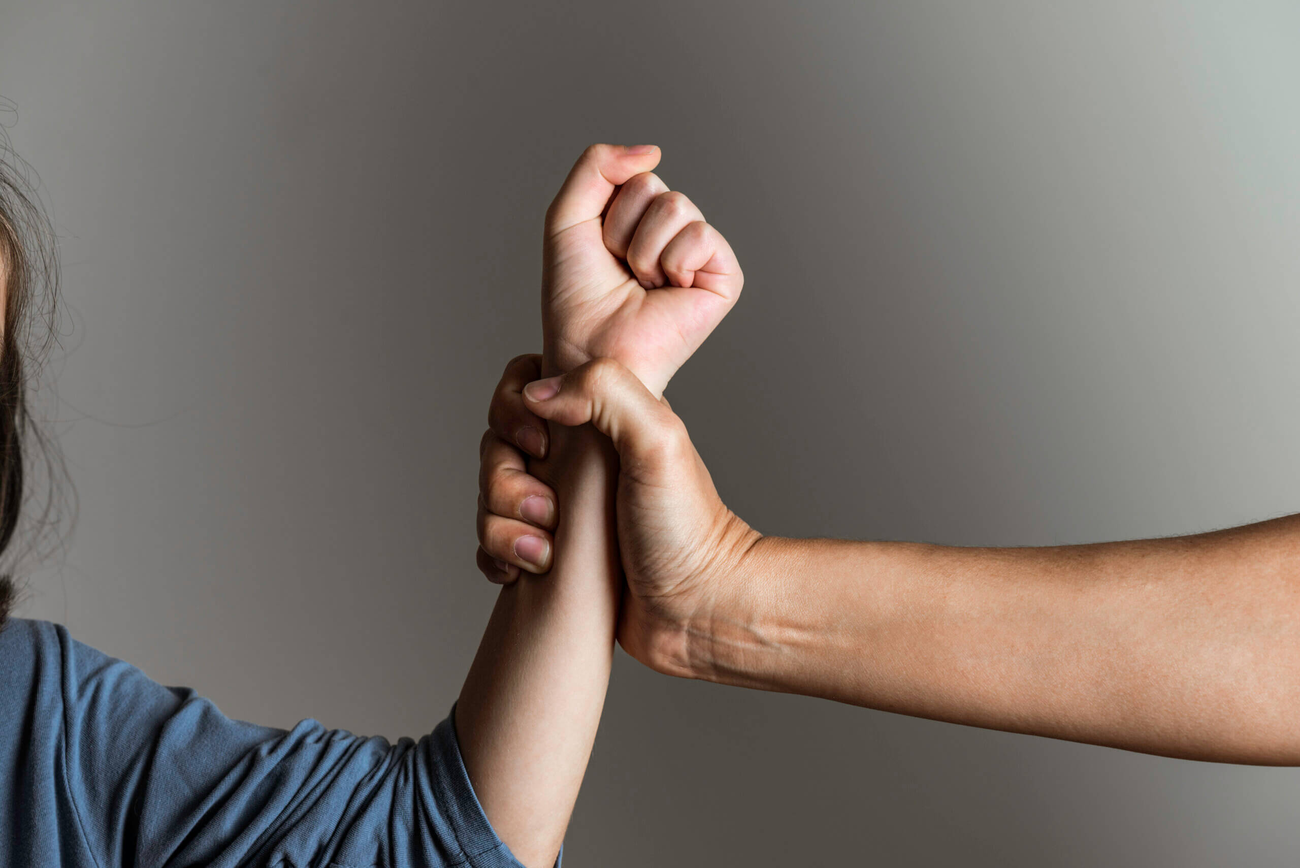 A woman gently raises her hand towards a child, conveying a sense of guidance and connection between them